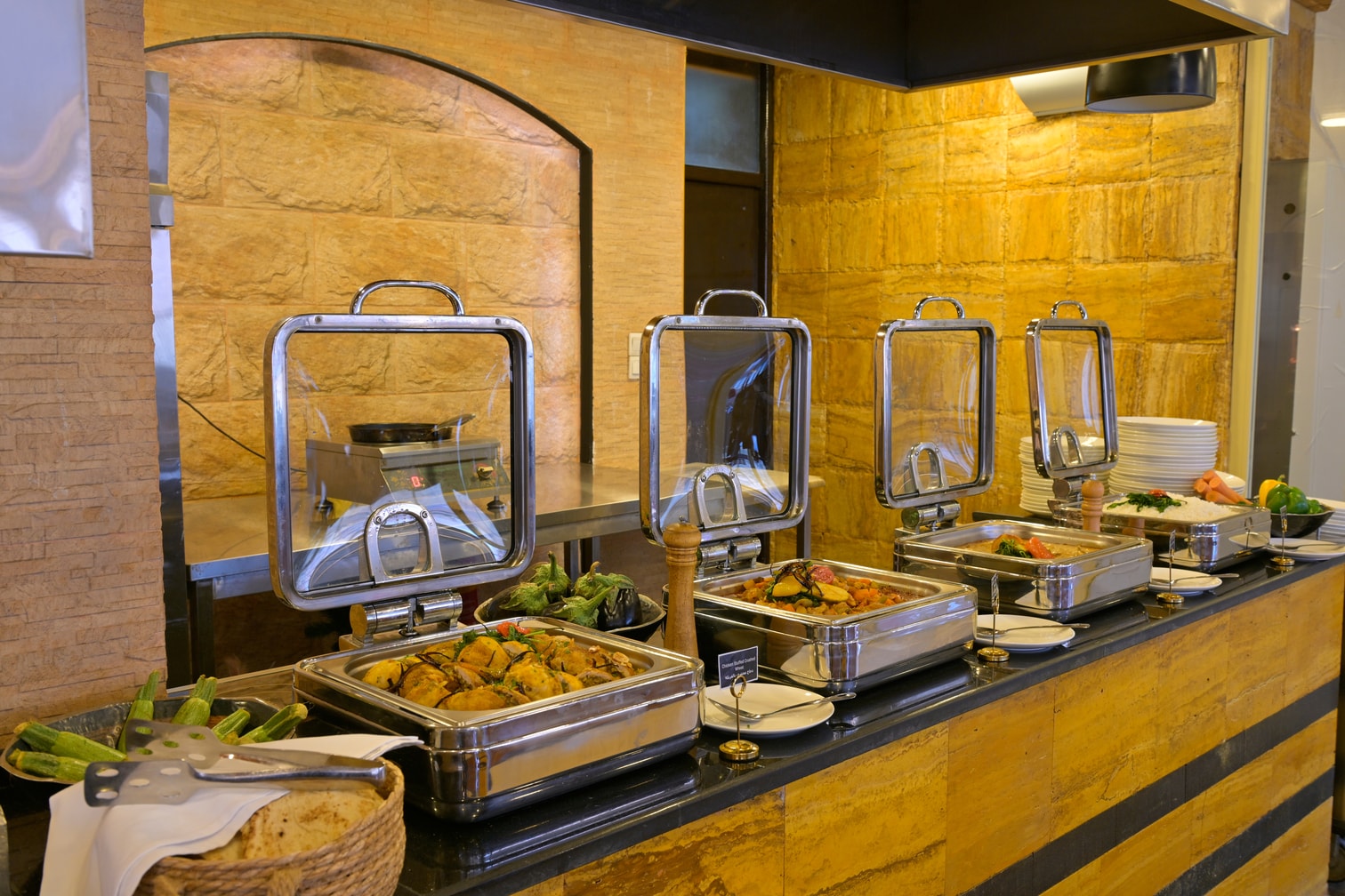 Hot buffet dishes in Petra Breeze Restaurant's stone-finished dining area