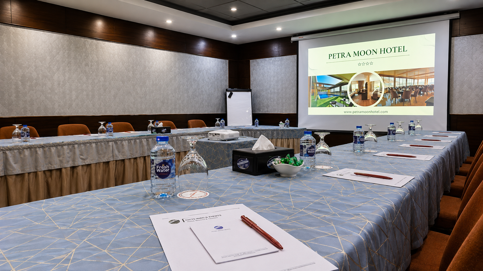 Moon Meeting Room prepared with conference tables, refreshments and presentation screen